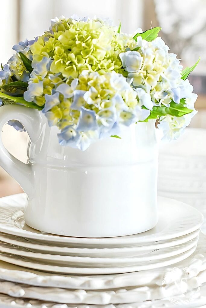 DECORATING WITH RISERS- pitcher of hydrangeas on a stack of plates