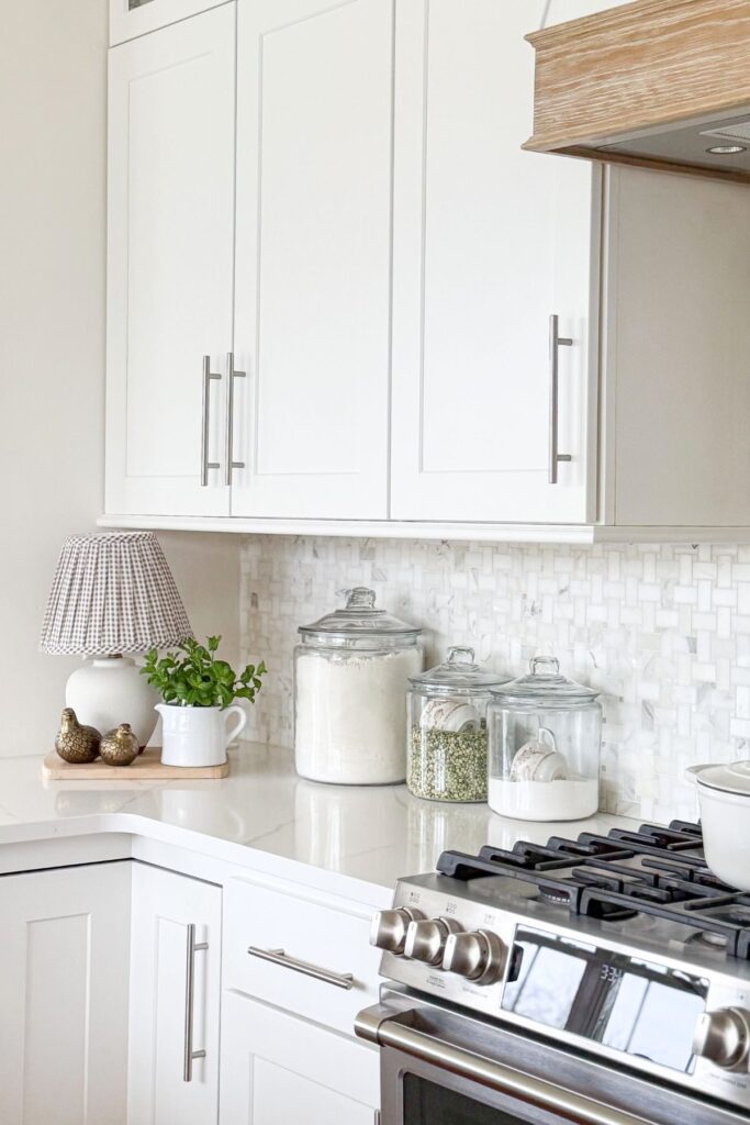 spring kitchen decorating ideas with counter corner styling, lamp, canisters, and small plant