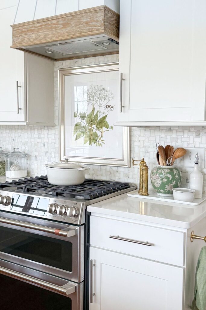 spring kitchen decorating ideas with botanical artwork above stove and green accents on countertop