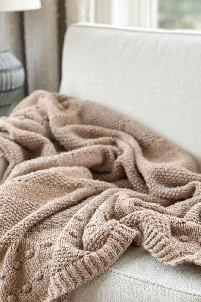 How to style a throw blanket draped and scrunched on a neutral sofa