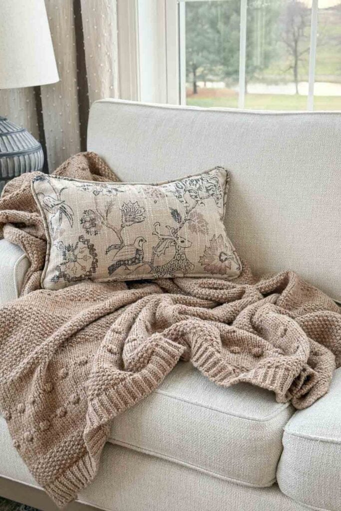 How to style a decorative throw with pillows on a neutral sofa