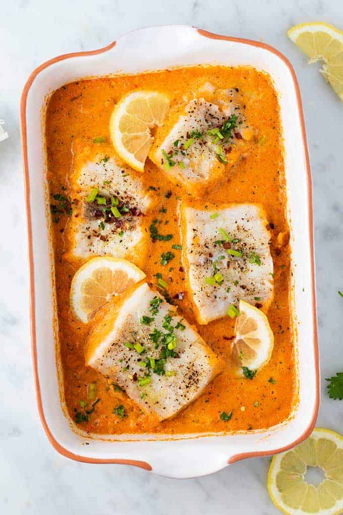 cod in red pepper sauce in a baking dish