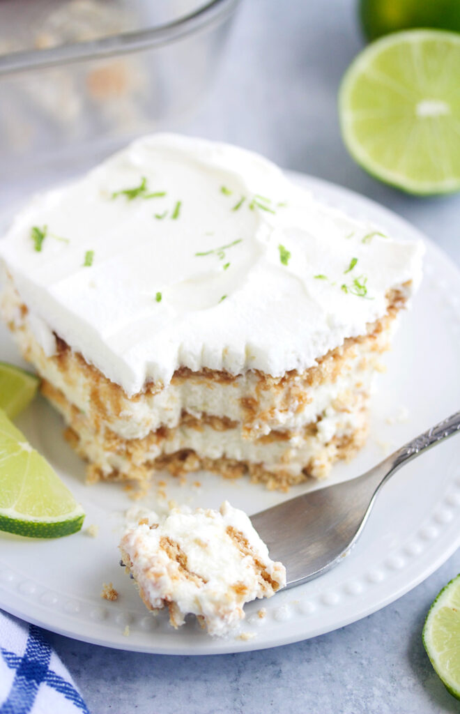 slice of key lime icebox cake with cut limes in the background