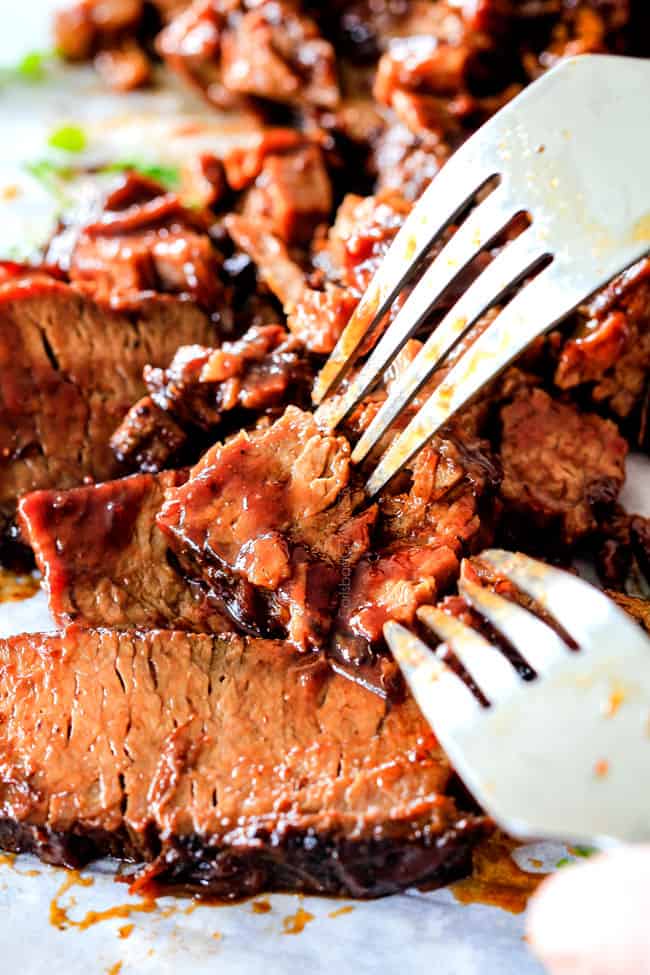 slow cooker beef brisket being pulled apart with forks