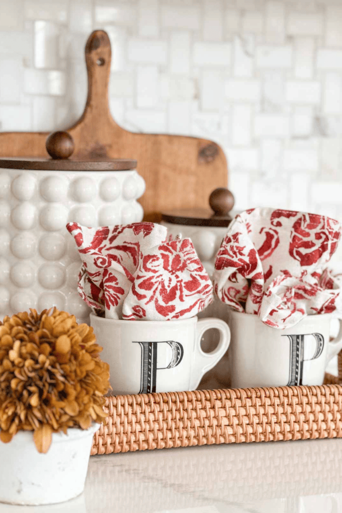 coffee mugs with colorful napkins in them in a wicker basket