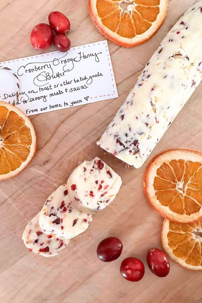 Cranberry orange honey butter in a small dish with a butter knife, a sweet and festive spread for holiday breads and rolls.