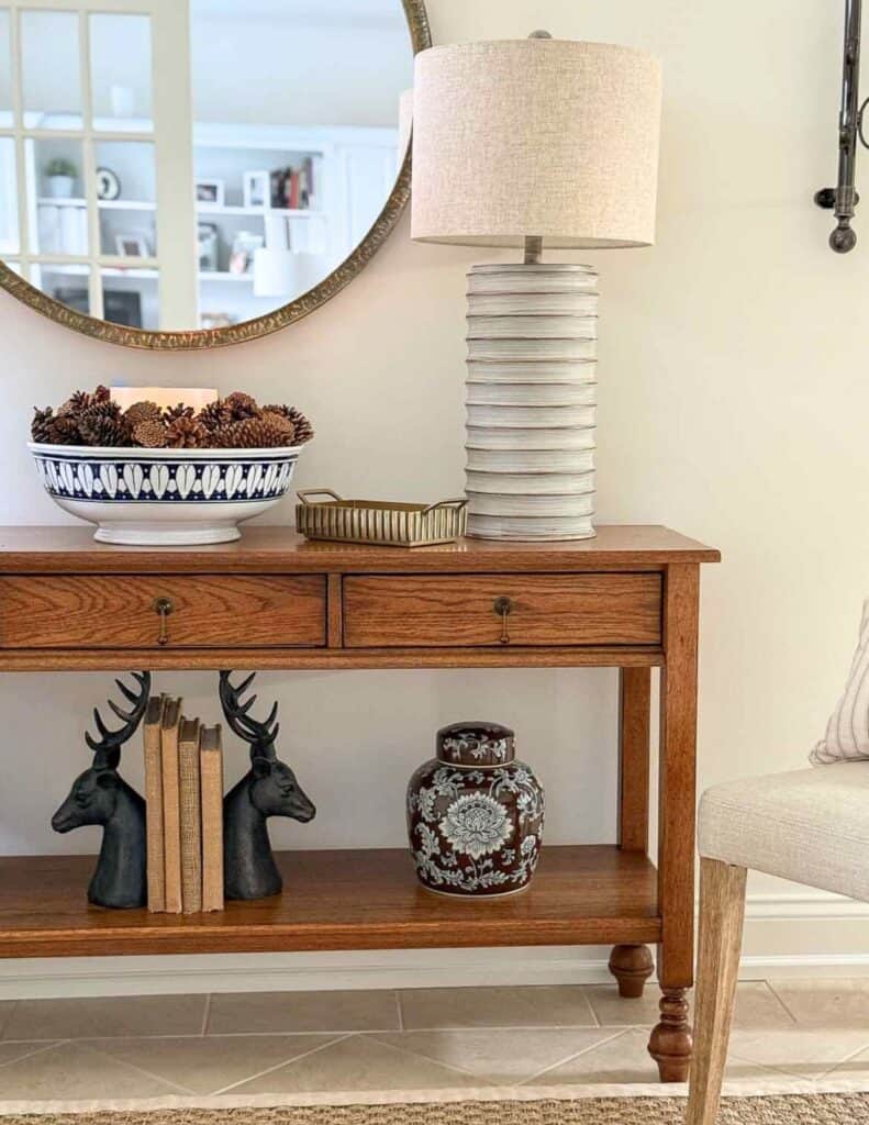 foyer table with a bowl of pinecones and a small brass tray