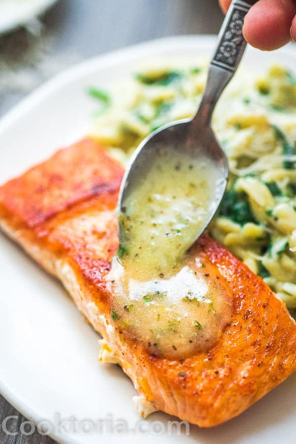 salmon on a plate with sauces being poured over it