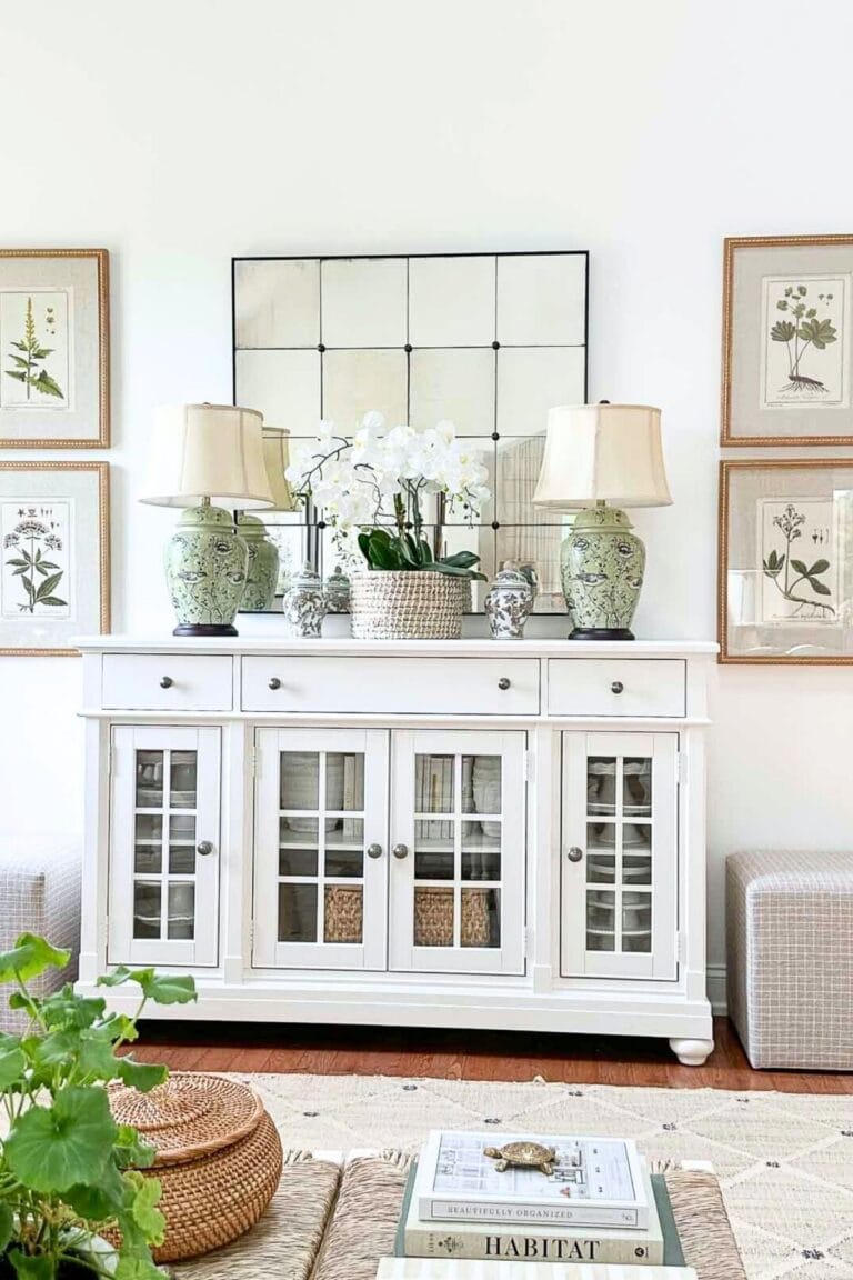 A white living room with a large buffet and a large mirror.
