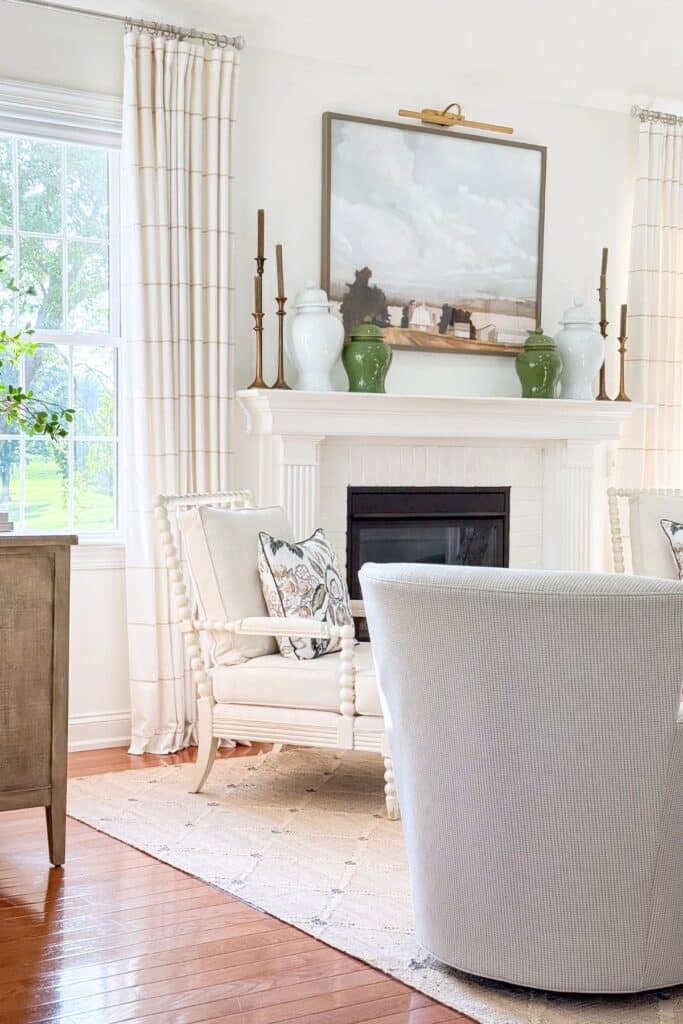 neutral living room with green ginger jars on a white fireplace mantel and a landscape painting above at Tanglewood