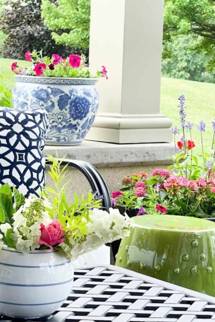 Three flower planters on a porch in varying heights and colors showing the rule of three outdoors