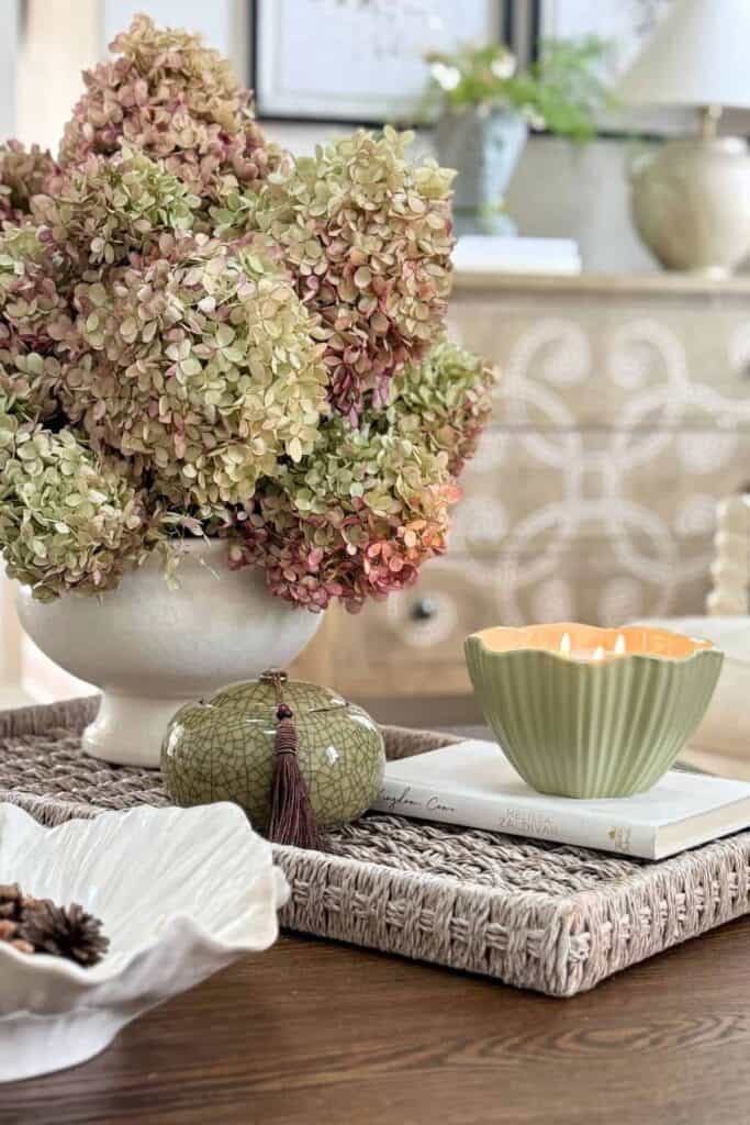coffee table styled with tray, hydrangeas, candle, and decorative accessories