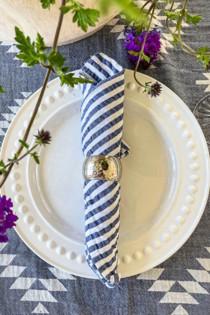 white dish with a blue and white striped napkin- place setting