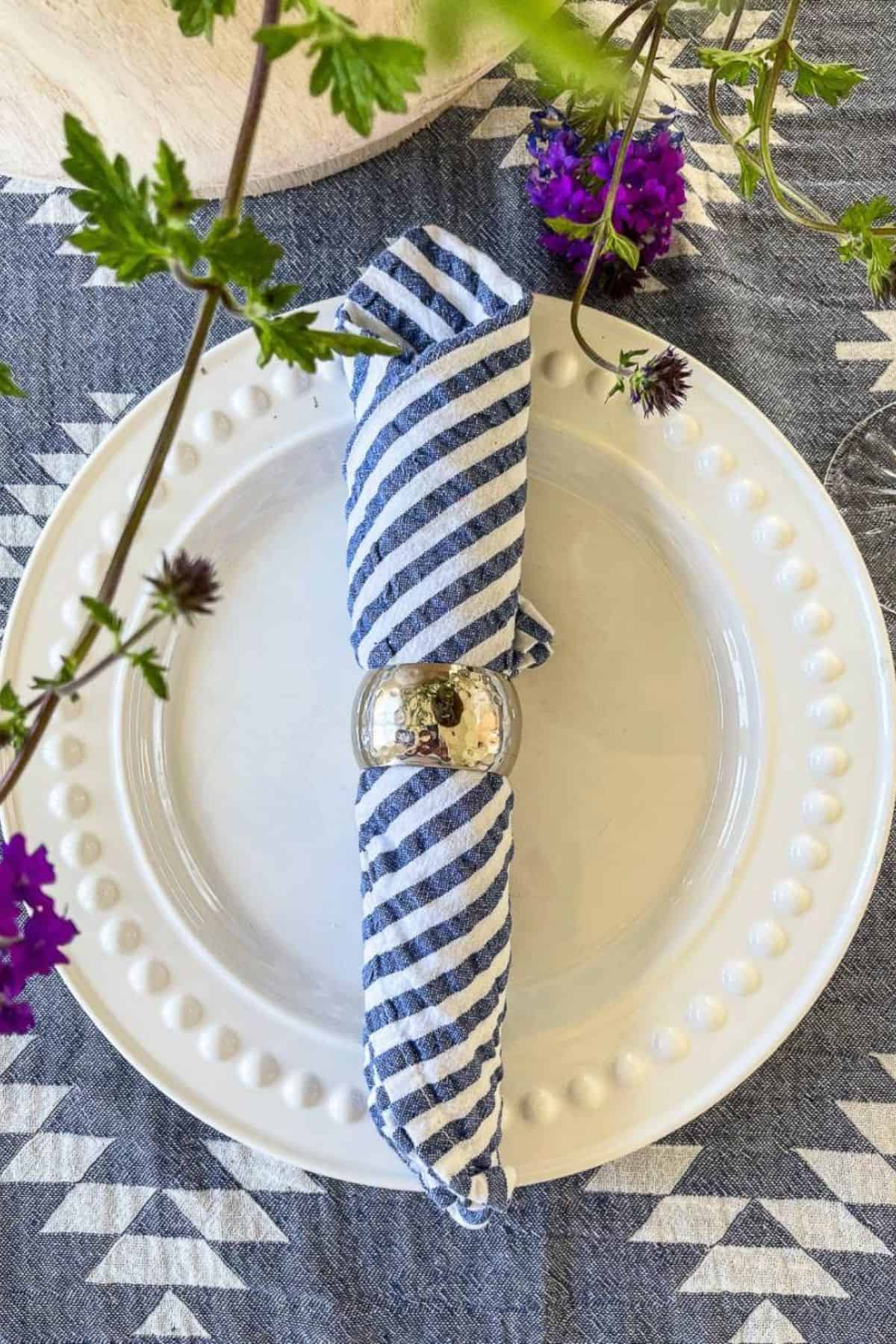white dish with a blue and white striped napkin- place setting