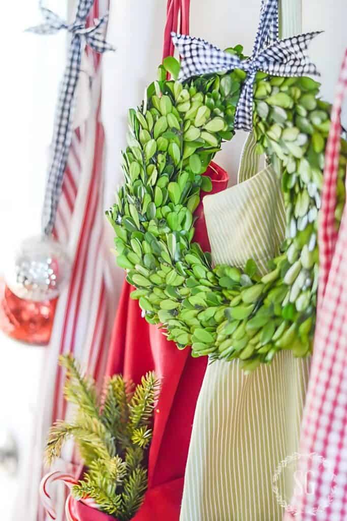 Christmas boxwood wreath hanging with aprons