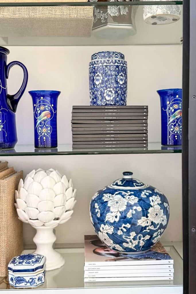 “decorating a bookshelf with stacked books and a decorative topper”