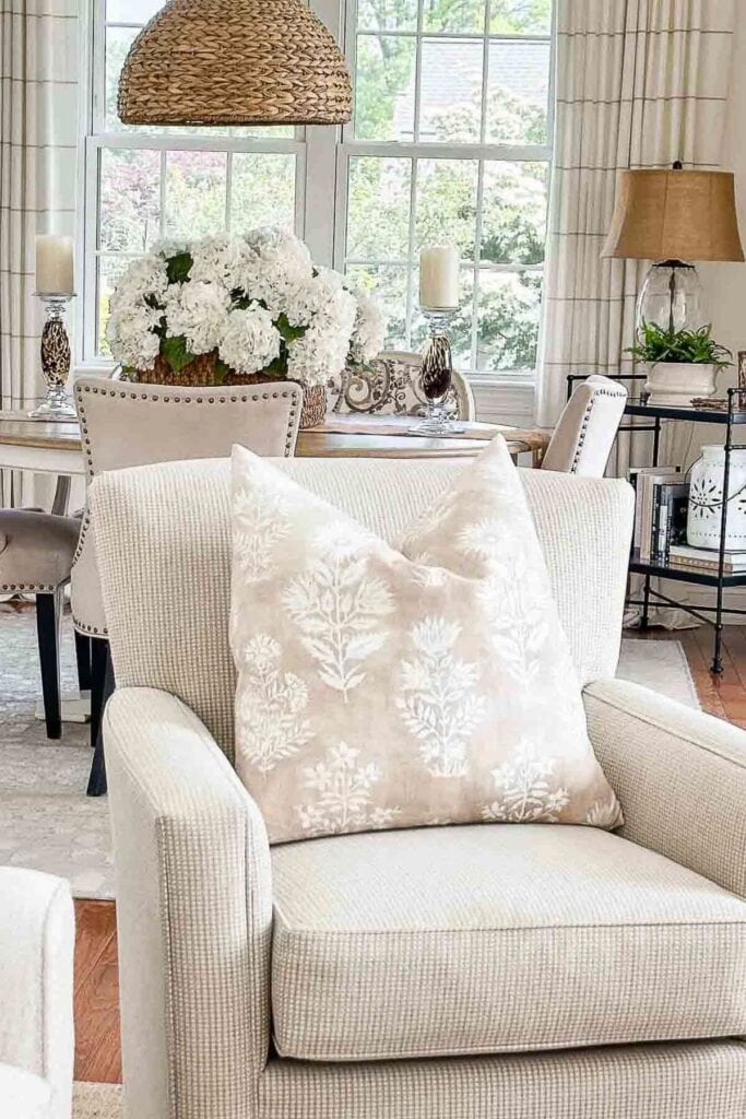 Soft neutral living room with cozy armchair and elegant decor for warm, inviting home atmosphere.