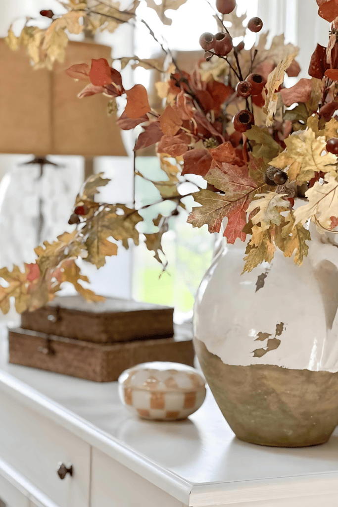 urn with fall leaves on a white buffet