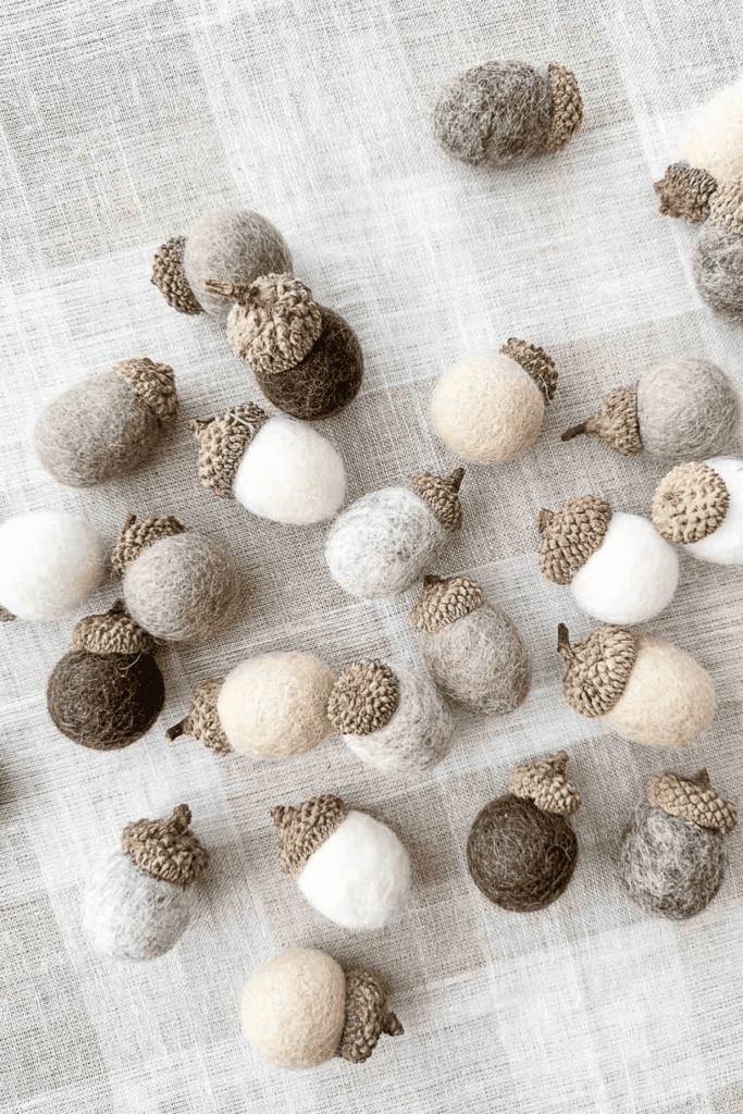 Wool Ball Acrorn Diy: assorted wool ball acorns on a plaid cloth