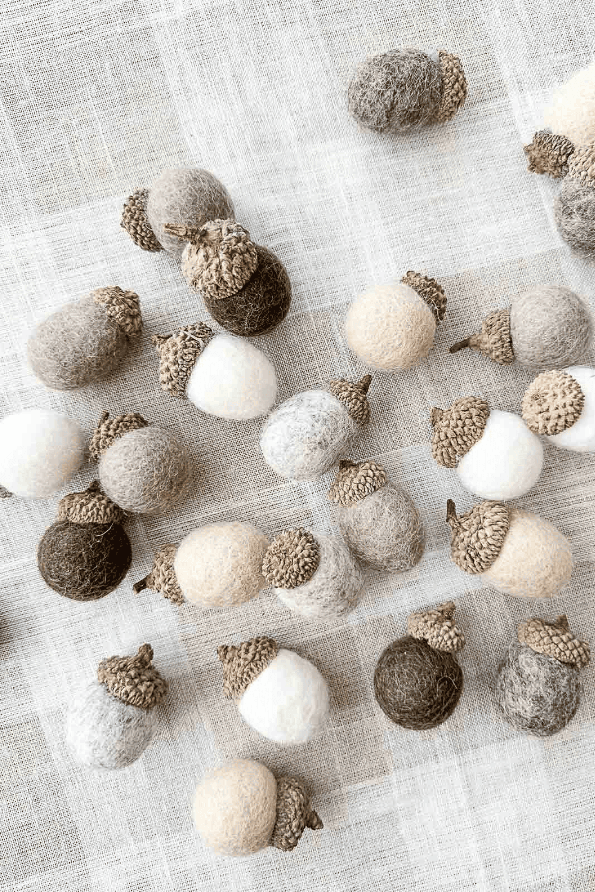 Wool Ball Acrorn Diy: assorted wool ball acorns on a plaid cloth