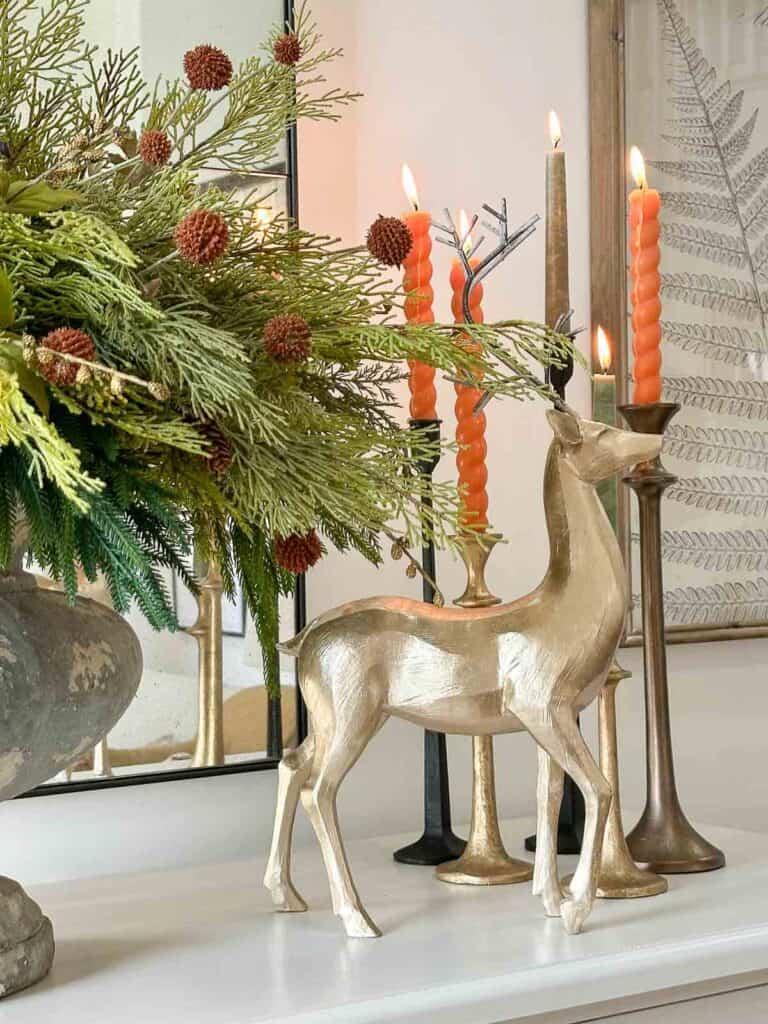 urn of evergreens, a gilded reindeer, and an assortment of candles