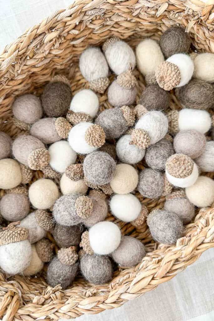 vintage woven basket filled with neutral felt acorns used for decorating