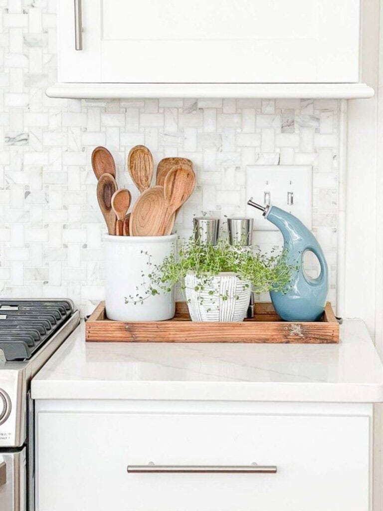 Decorating Kitchen Countertops- tray with a crock of utinsels, salt and pepper shaker, oil dispenser, and a thyme plant.
