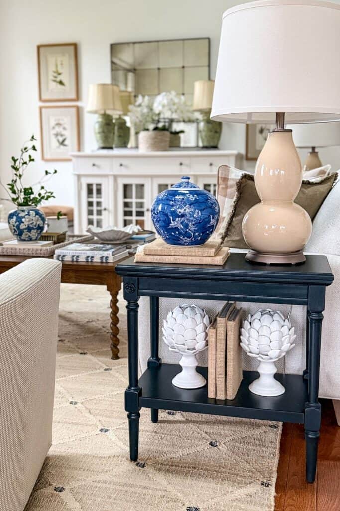 black end table with a natural colored lamp and other accent decor