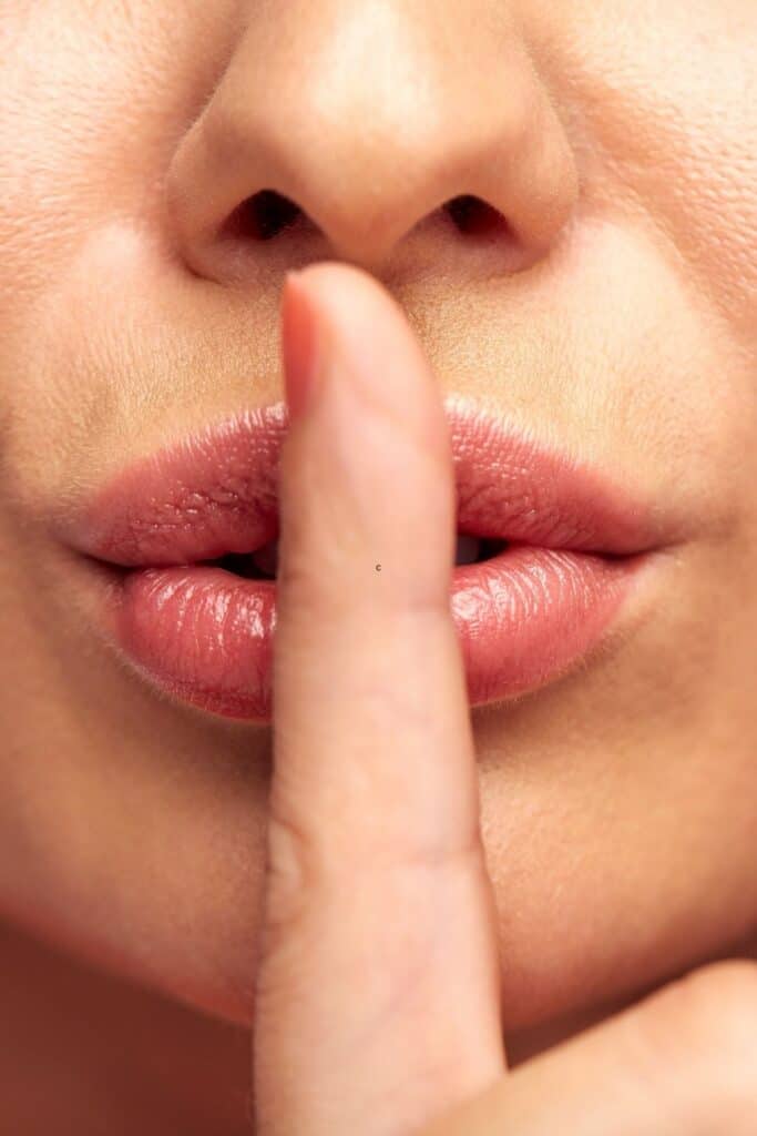 woman with her lips covered by her finger