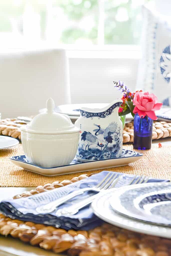 Blue and white tablescape with hot pink roses in a tiny vase