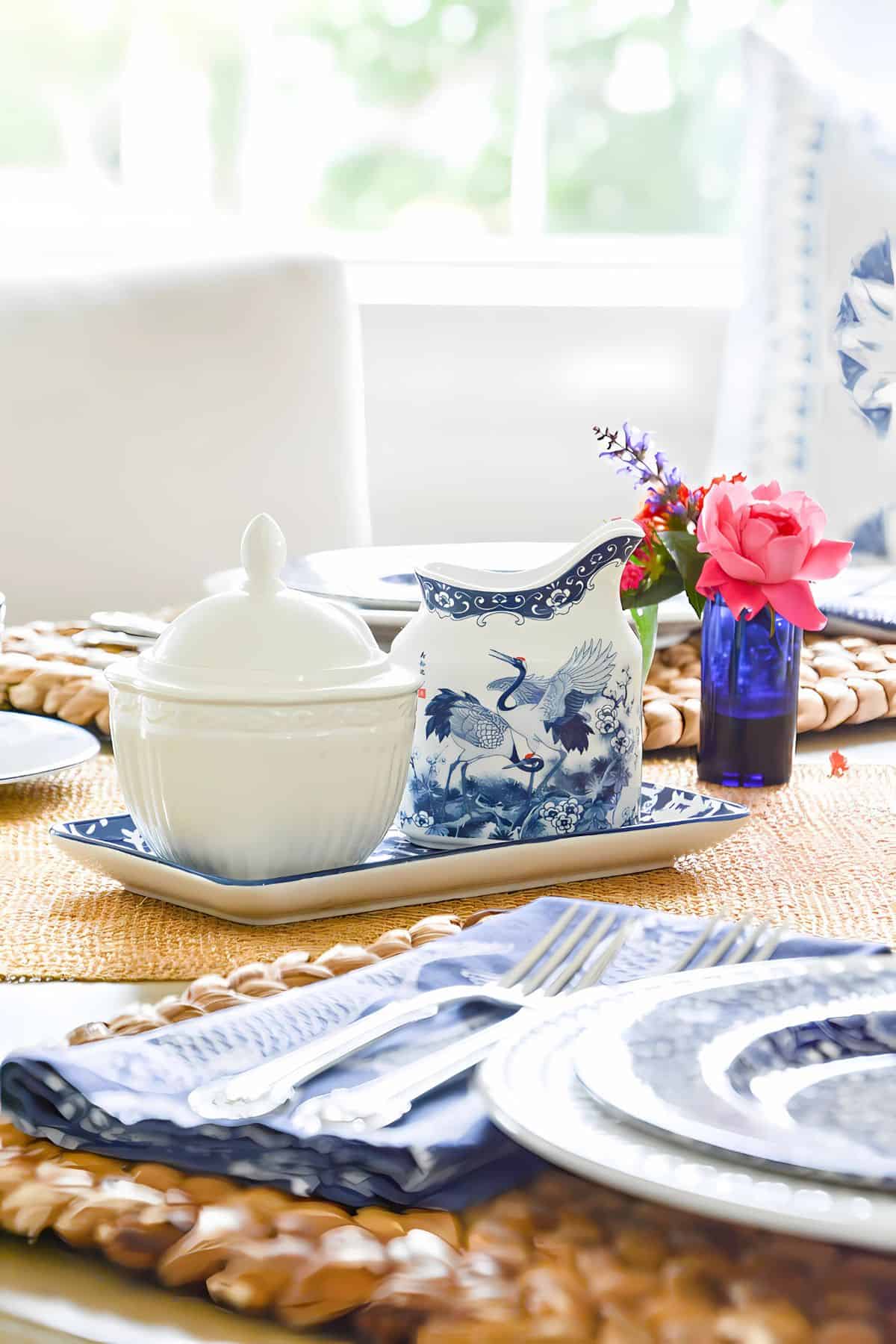 Blue and white tablescape with hot pink roses in a tiny vase