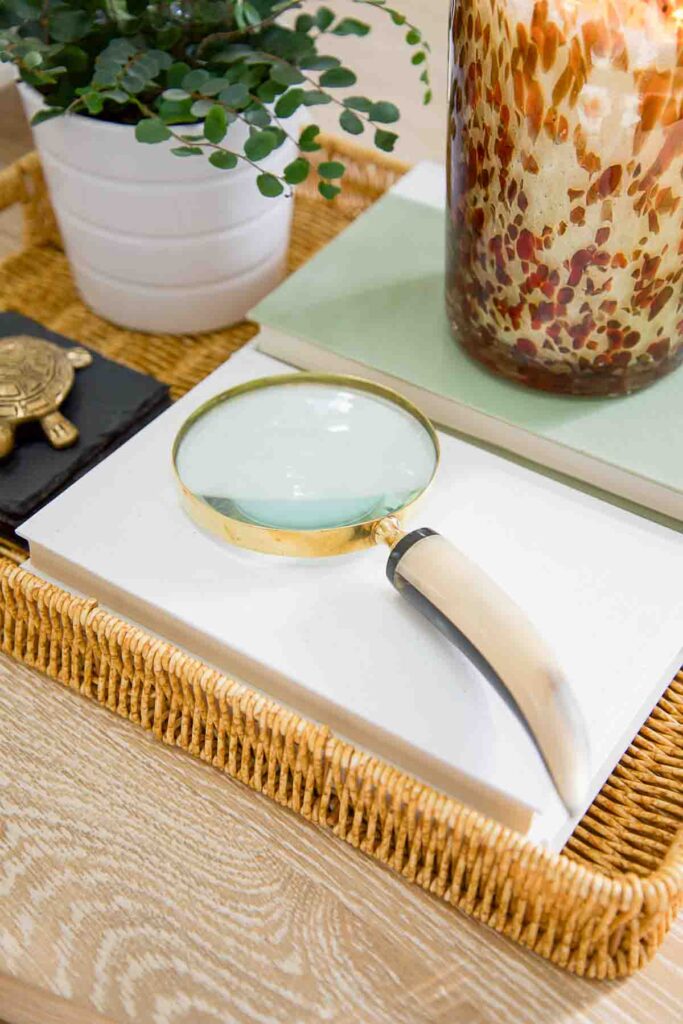 a horn handled magnifying glass on top of books