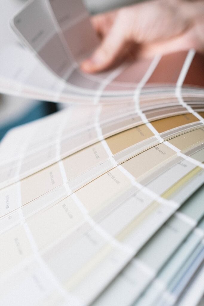 Fanned paint color deck showing a range of beige and tan paint chips from light to deep