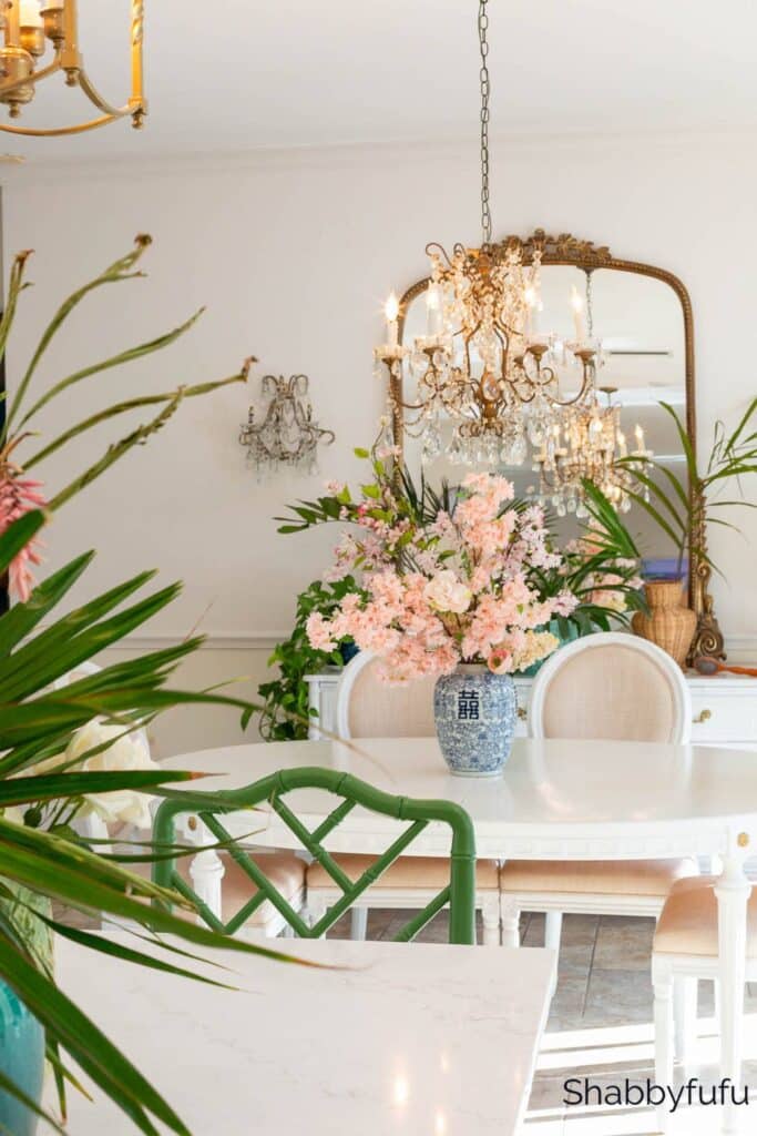 dining room that looks expensive with a chandelier and a gilded mirror