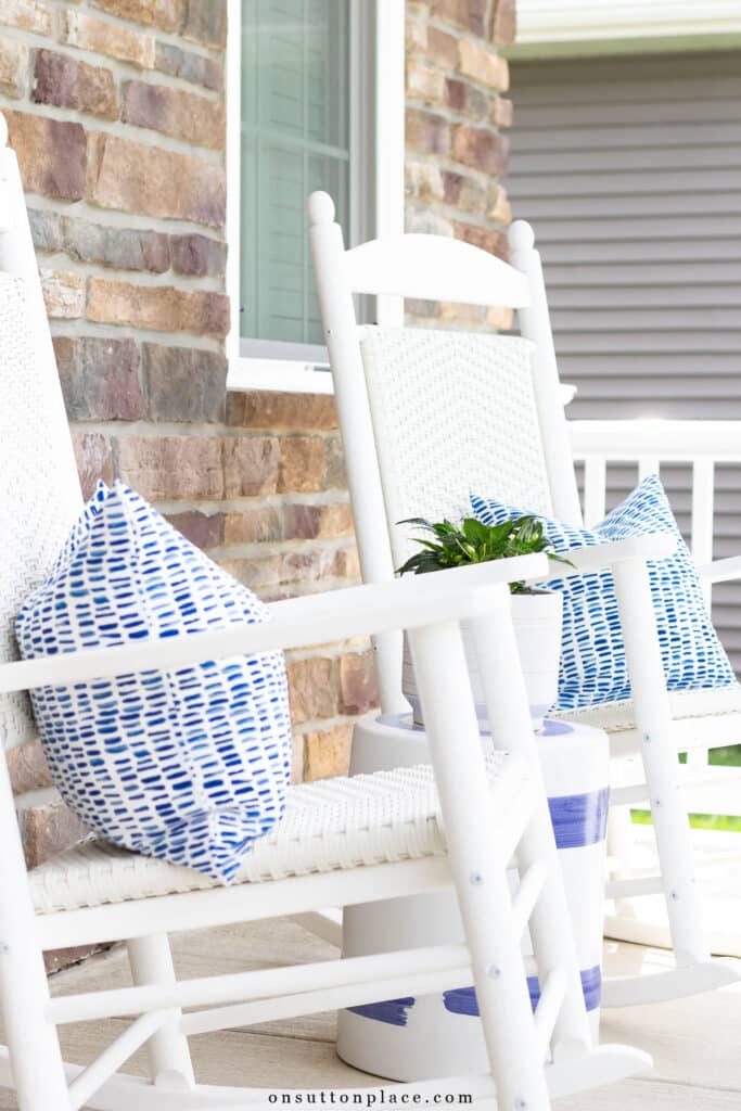 white rockers on a porch with blue and white pillows on them