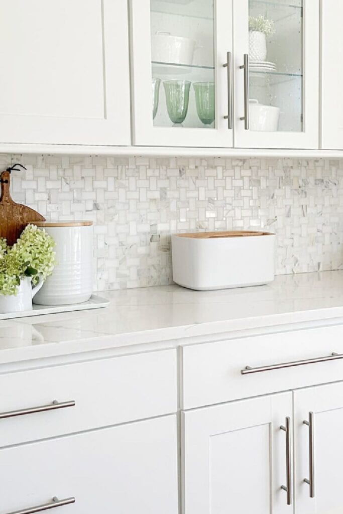 white kitchen counter with bread box, canister, and simple decor for organized countertop
