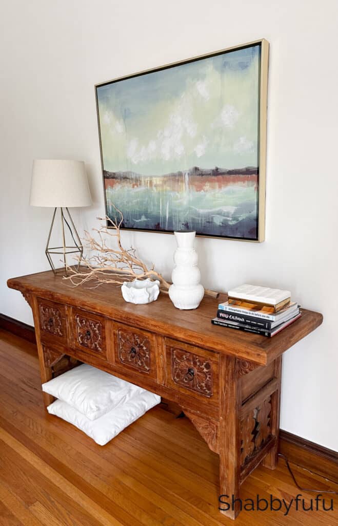 console with a modern painting above it