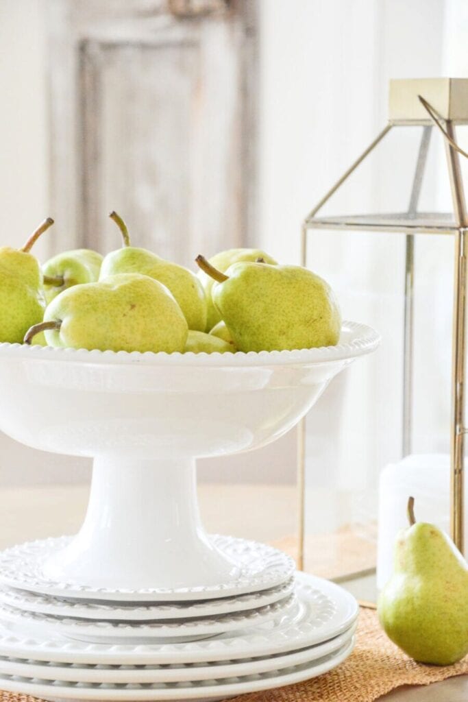 dining table centerpiece ideas using pears in a bowl with simple layered decor