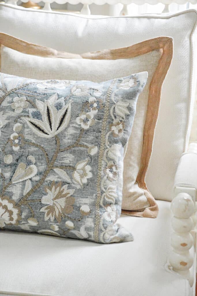 layered pillows on a white spindle chair