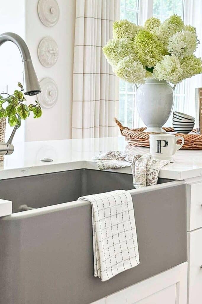 simple kitchen ideas styling a sink area with hydrangeas, a tray, and kitchen accessories on a white countertop
