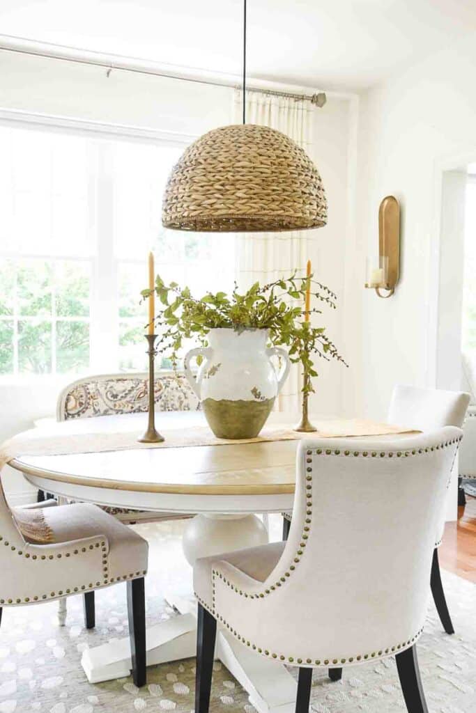 DINING ROOM TABLE WITH A LARGE URN WITH GREENS
