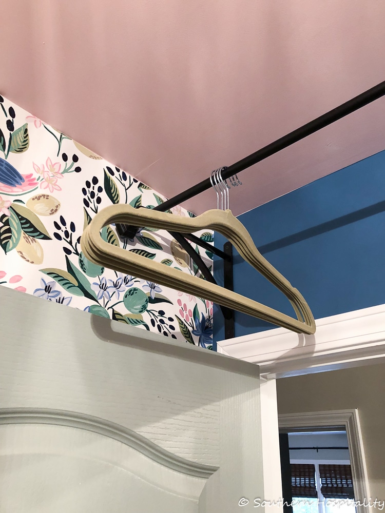 a hanging drying rod for clothes in a laundry room