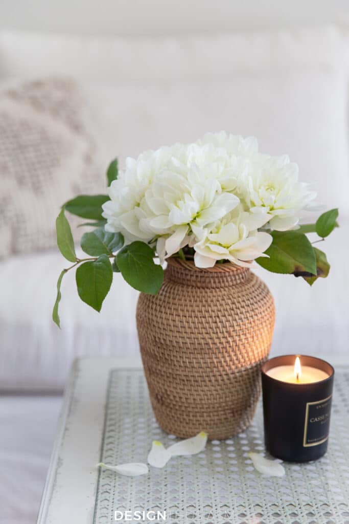 flowers in a wicker vase with a small candle