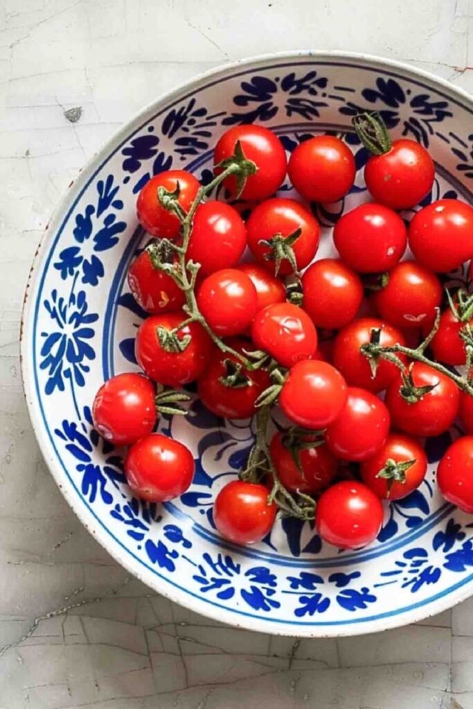 Fresh cherry tomatoes on the vine in a blue and white bowl for late summer kitchen decor