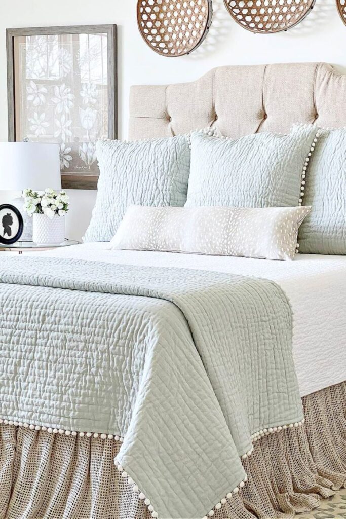 Neatly made bed with layered pillows and a quilted coverlet in a primary bedroom