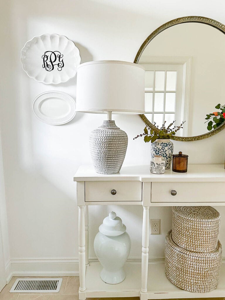 foyer table and plates hanging on a foyer wall