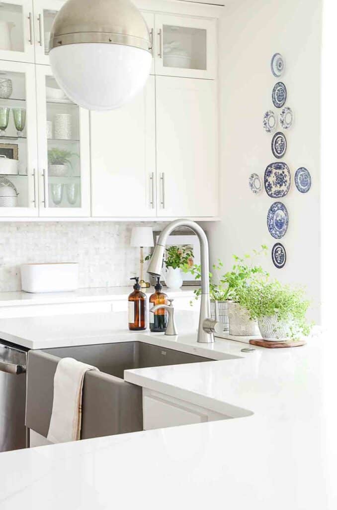KITCHEN SINK WITH PLATES ON THE WALL IN THE BACKGROUND