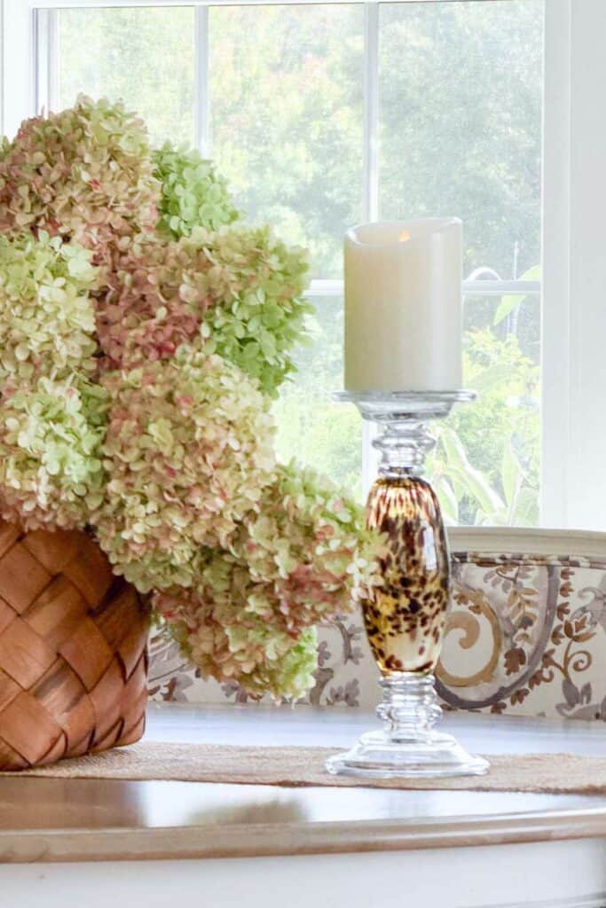 dried limelight hydrangeas in a basket on the dining room table + a tortoise shell candlestick