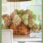 Basket of dried green and brown hydrangeas styled on a dining room table, a beautiful example of budget-friendly fall decorating.