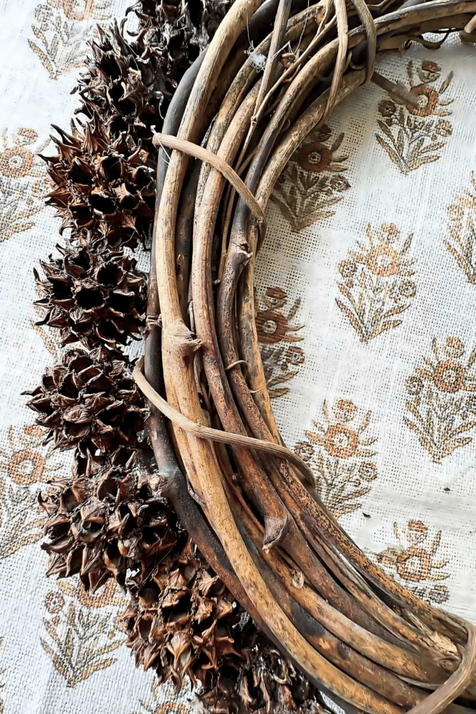 GLUE SWEET GUM BALL ON THE IOUTSIDE OF THE WREATH